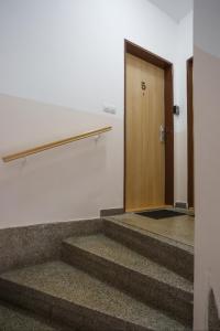 um quarto vazio com escadas e uma porta de madeira em Diana Apartments Karlovy Vary em Karlovy Vary
