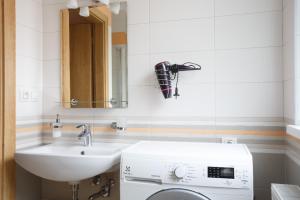 uma casa de banho com um lavatório e uma máquina de lavar roupa em Diana Apartments Karlovy Vary em Karlovy Vary