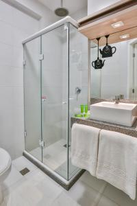baño con cabina de ducha de cristal y lavamanos en ibis Styles Vitoria da Conquista, en Vitória da Conquista