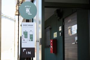 a sign in front of a building with a guest house at Kulton Moct Kenroku in Kanazawa