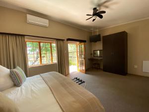 a bedroom with a bed and a ceiling fan at Lanseria Country Estate in Lanseria