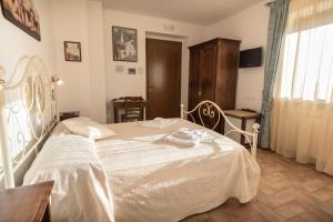 アッシジにあるAgriturismo Dolce Sentireのベッドルーム1室(白いベッド1台、テーブル、窓付)