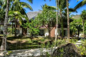 a house with palm trees in front of it at ROYAL BORA BORA in Bora Bora