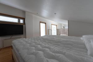 Un dormitorio con una cama grande y un televisor de pantalla plana. en Vuokraruka, en Kuusamo