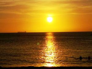 una puesta de sol sobre el océano con la puesta de sol en Rancho Ayala, en Santa Marta