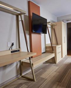a living room with a tv and a table with a table at Holiday Inn Express Hotel & Suites Athens by IHG in Athens