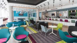 a restaurant with colorful chairs and tables and a bar at Holiday Inn Express Aberdeen Airport by IHG in Dyce