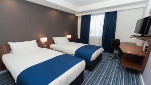 a hotel room with two beds and a television at Holiday Inn Express Aberdeen Airport by IHG in Dyce