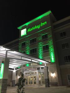 a holiday inn building with green lights in the night at Holiday Inn Abilene - North College Area, an IHG Hotel in Abilene