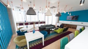 a waiting room with blue walls and chairs and tables at Holiday Inn Express Aberdeen Airport by IHG in Dyce