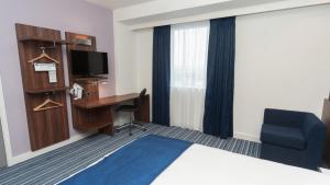 a hotel room with a bed and a desk and a tv at Holiday Inn Express Aberdeen Airport by IHG in Dyce