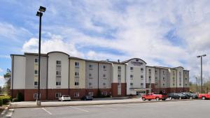 a large building with cars parked in a parking lot at Candlewood Suites Athens by IHG in Athens