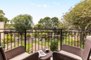 a balcony with chairs and a view of a park at Holiday Inn Auckland Airport by IHG in Auckland