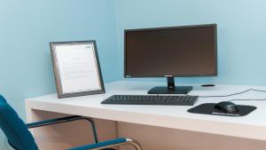 a computer monitor and a keyboard and mouse on a desk at Holiday Inn Express Aberdeen Airport by IHG in Dyce