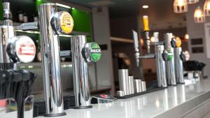 a row ofbeer taps on a counter in a bar at Holiday Inn Express Aberdeen Airport by IHG in Dyce