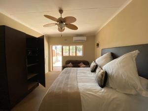 a bedroom with a bed with a ceiling fan at Lanseria Country Estate in Lanseria +203 photos