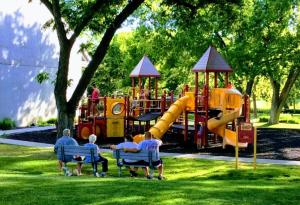 eine Gruppe von Menschen, die auf einem Spielplatz auf Stühlen sitzen in der Unterkunft Holiday Inn Express - Alliance, an IHG Hotel in Alliance