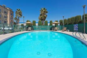 a swimming pool with blue water in a resort at Holiday Inn Express Bakersfield by IHG in Bakersfield