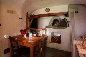 comedor con mesa y horno de pizza en Redelnascht, en Gressoney-la-Trinité