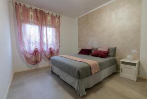 um quarto com uma cama e uma janela com cortinas cor-de-rosa em Profumo di casa em Trescore Balneario
