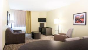 pokój hotelowy ze stołem i krzesłami w obiekcie Candlewood Suites Bay City, an IHG Hotel w mieście Bay City