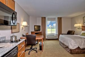 a hotel room with a bed and a desk at Candlewood Suites Burlington, an IHG Hotel in Burlington