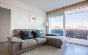 - un salon avec un canapé et une grande fenêtre dans l'établissement Calafell playa lateral mar, à Calafell