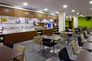 a restaurant with tables and chairs and a counter at Holiday Inn Express Barcelona City 22@, an IHG Hotel in Barcelona