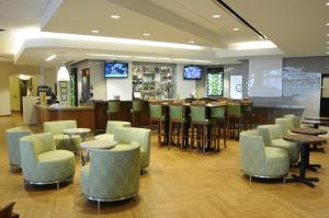a restaurant with a bar with chairs and tables at Holiday Inn Columbia East-Jessup, an IHG Hotel in Jessup