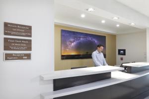 a man standing in a room with a large painting on the wall at Candlewood Suites - Celaya by IHG in Celaya