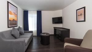 a living room with a couch and a tv at Candlewood Suites - Celaya by IHG in Celaya