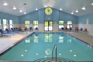 a swimming pool with chairs and a clock on the wall at Holiday Inn Express Hotel & Suites Batesville, an IHG Hotel in Batesville