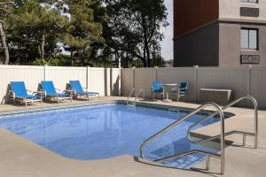 una piscina con sillas azules y una valla en Holiday Inn Express Boston - Saugus, an IHG hotel en Saugus
