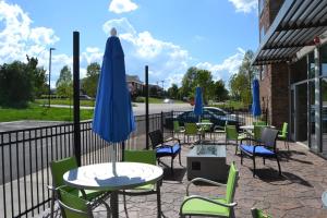 a patio with tables and chairs and a blue umbrella at Holiday Inn Express & Suites Goodlettsville N - Nashville, an IHG Hotel in Goodlettsville