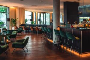 um restaurante com cadeiras verdes e um bar em Holiday Inn Berlin City Center East Prenzlauer Berg, an IHG Hotel em Berlim