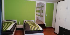 2 letti in una camera con pareti verdi di Ferienwohnung Sonnwald a Dusseldorf
