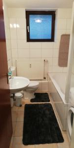 een badkamer met een bad, een toilet en een wastafel bij Ferienwohnung Sonnwald in Düsseldorf +7 foto's