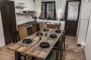 a kitchen with a wooden table with plates on it at Elatos Luxury Villas Erato in Sinaia