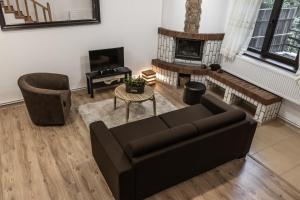 Una sala de estar con un sofá y una chimenea. en Elatos Luxury Villas Erato, en Sinaia