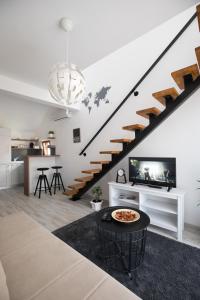 a living room with a staircase with a tv and a table at Apart 31 in Cetinje