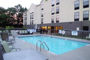 a large swimming pool with chairs and a building at Holiday Inn Express Hotel & Suites Blythewood by IHG in Blythewood