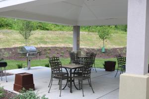 eine Terrasse mit einem Tisch, Stühlen und einem Grill in der Unterkunft Candlewood Suites Nashville - Goodlettsville, an IHG Hotel in Goodlettsville