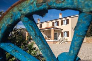 una casa vista attraverso una recinzione di ferro blu di Villa Poduniz a Punat
