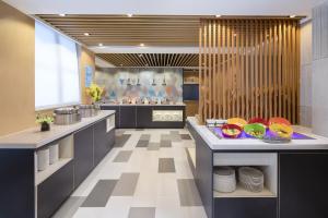 a large kitchen with a counter with plates on it at Holiday Inn Express Foshan Chancheng, an IHG Hotel in Foshan