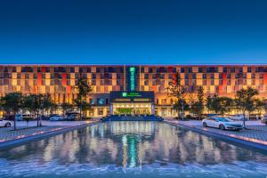 un edificio con una gran fuente frente a él en Holiday Inn Express Zhengzhou Airport, an IHG Hotel, en Xinzheng