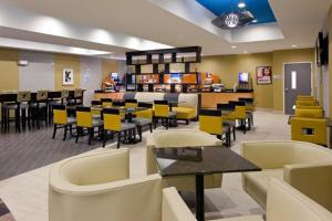 a dining room with tables and yellow chairs at Holiday Inn Express and Suites Batavia, an IHG Hotel in Batavia