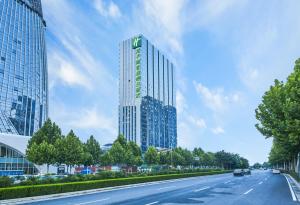 wysoki budynek przy drodze w obiekcie Holiday Inn Express Zhengzhou Longzi Lake, an IHG Hotel w mieście Yaoqiao