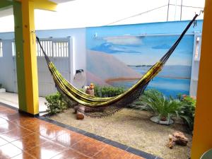 a hammock in a room with a mural at Pousada Recanto Cruzeiro in Barreirinhas