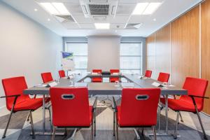 a conference room with a long table and red chairs at Holiday Inn Express Walsall M6, J10, an IHG Hotel in Walsall