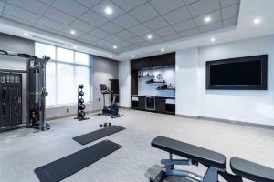 a gym with cardio equipment and a flat screen tv at Staybridge Suites - Quincy by IHG in Quincy